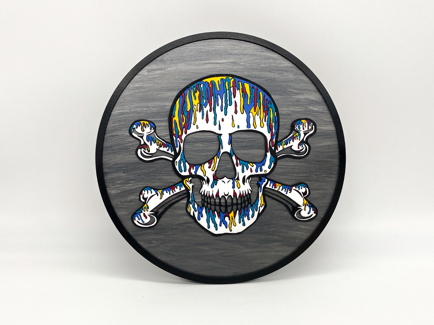 Decorative wall art with a colorful skull and crossbones design on a gray background
