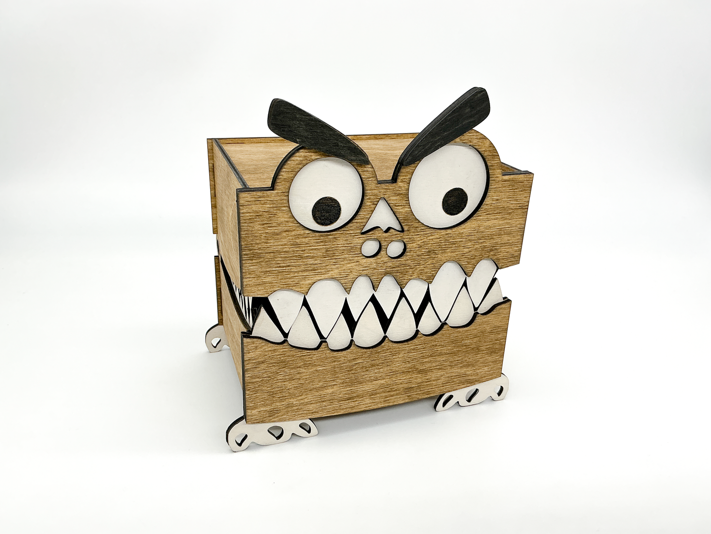A handcrafted wooden Monster Box stained in rich walnut, featuring googly eyes, thick eyebrows, white teeth, and small feet. Its quirky, toothy design makes it a fun and unique piece for Halloween decor or playful storage.