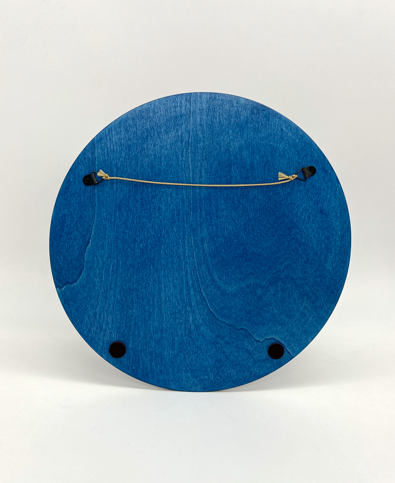 Blue circular object with a string and small weights on a white background