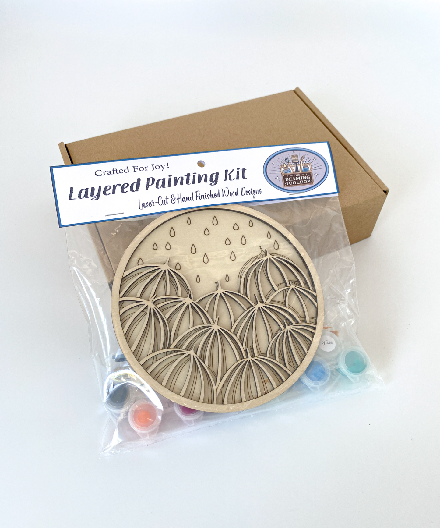 Layered painting kit with wooden craft kit and packaging on a white background