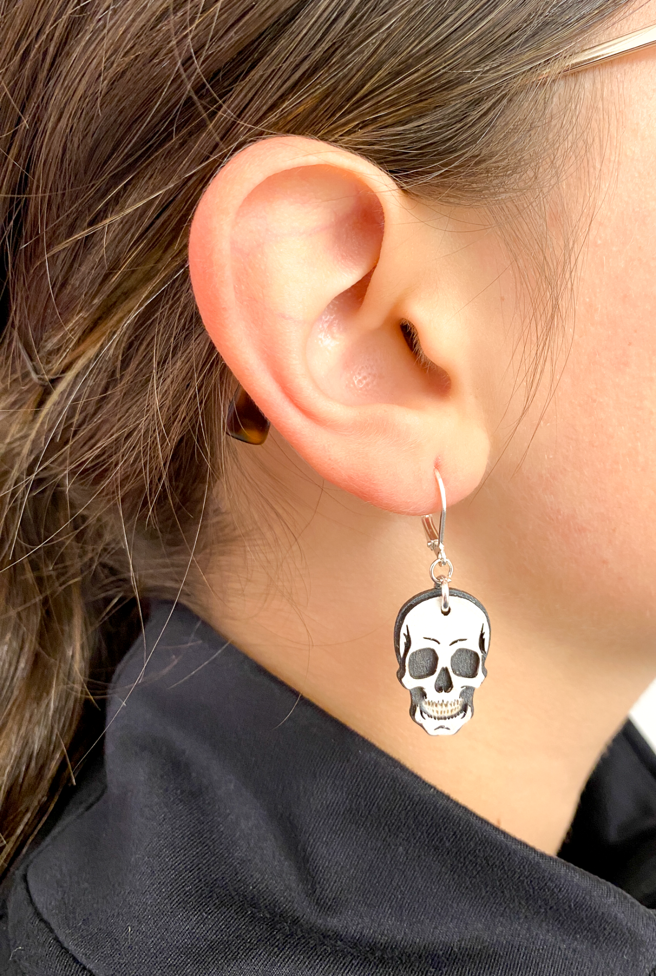 Close-up of an ear wearing a skull-shaped earring
