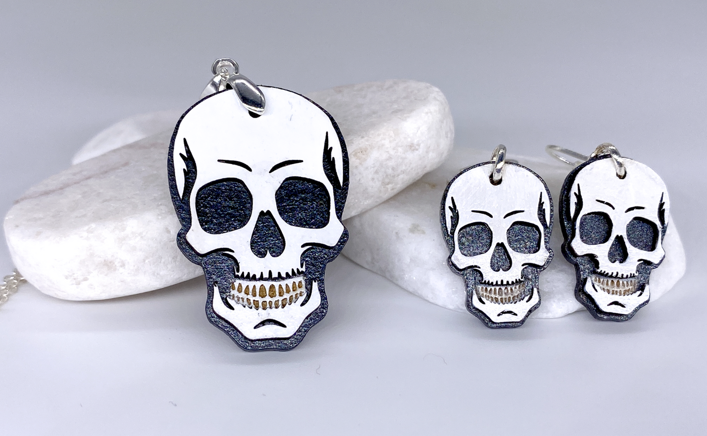 Skull-shaped earrings on a light gray background