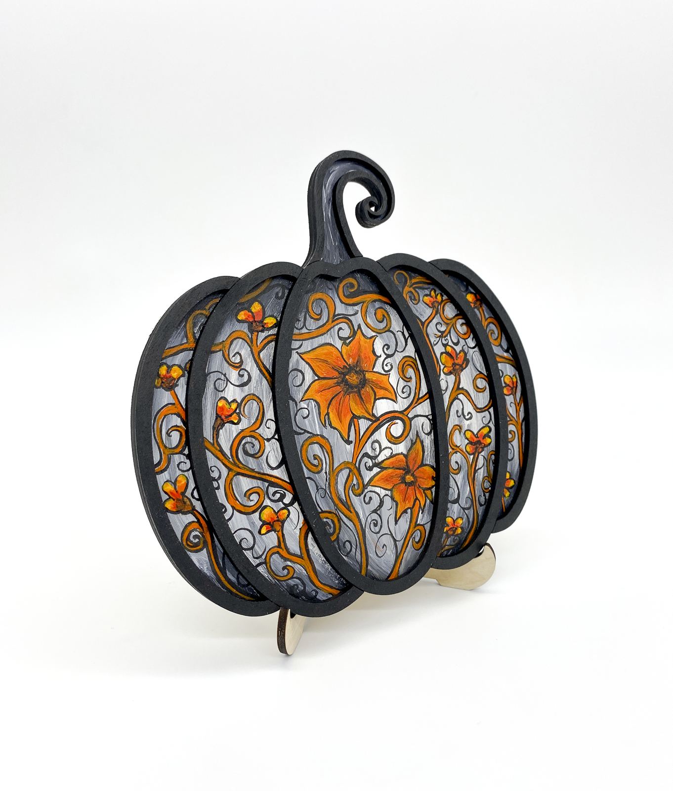 Decorative pumpkin-shaped plate holder with floral designs on a white background