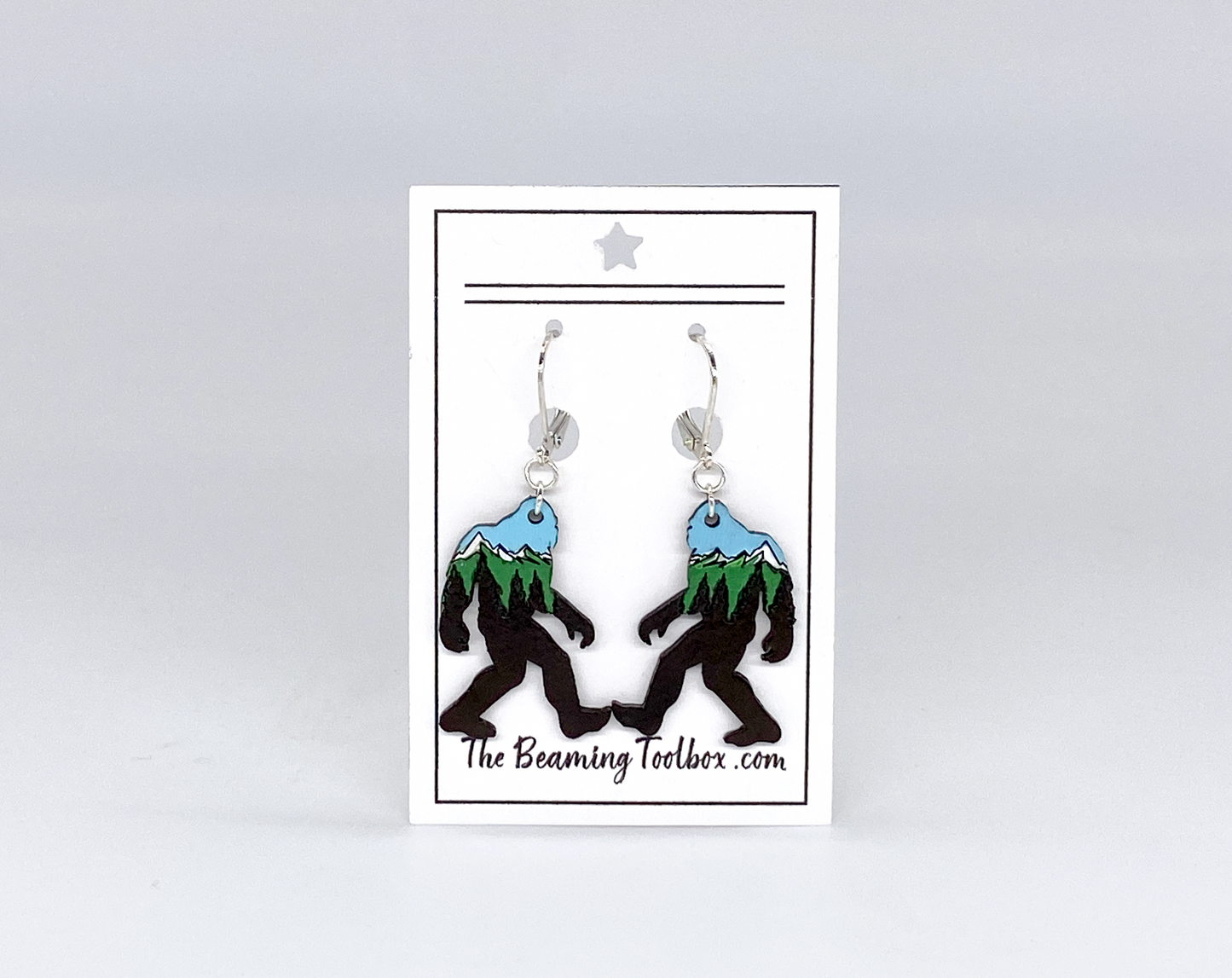 Sasquatch earrings on a card with 'The Beaming Toolbox' branding