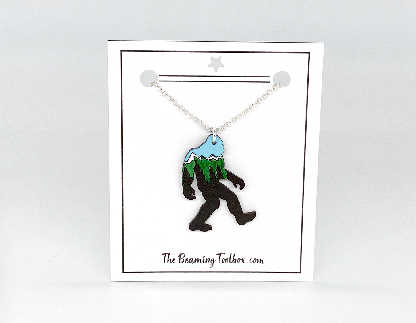 Necklace with a Bigfoot pendant on a white card with 'The Beaming Toolbox' branding.