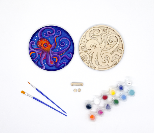 A DIY Paint Kit Featuring A Laser-cut Wooden Octopus, With A Set Of Acrylic Paints And Brushes For Creative Customization.
