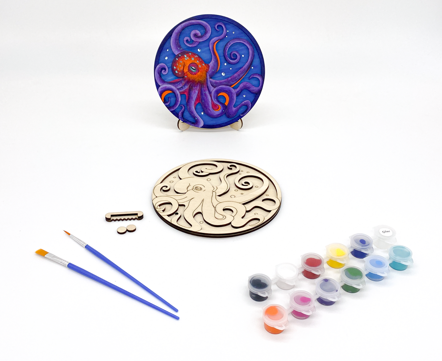 A DIY Paint Kit Featuring A Laser-cut Wooden Octopus, With A Set Of Acrylic Paints And Brushes For Creative Customization.