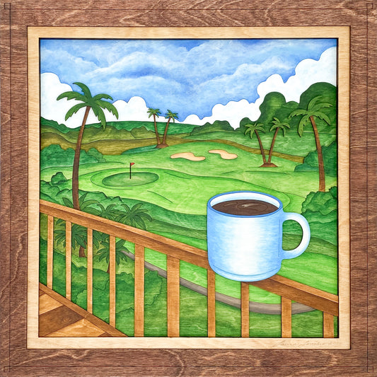 Framed artwork of a coffee cup on a deck overlooking a golf course with palm trees.