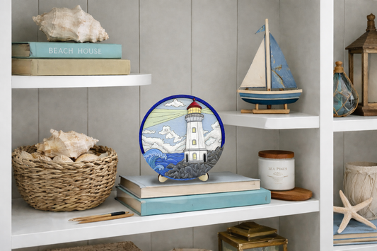 Layered wood lighthouse DIY paint kit displayed on a beach house bookshelf with coastal decor including seashells, sailboat model, and nautical accents