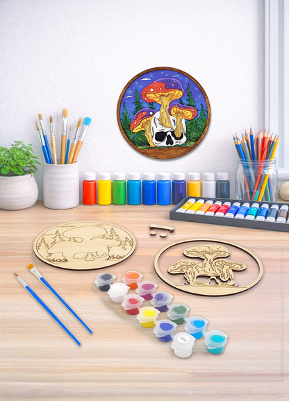 A 3D layered wood kit featuring a skull and mushroom design with paint pots and brushes for a DIY art project.