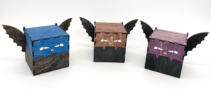 Three bat-shaped boxes with different color faces on a white background