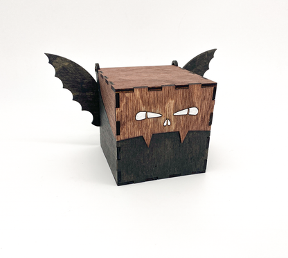 Handmade brown and black wood bat box with carved wings and hinged lid