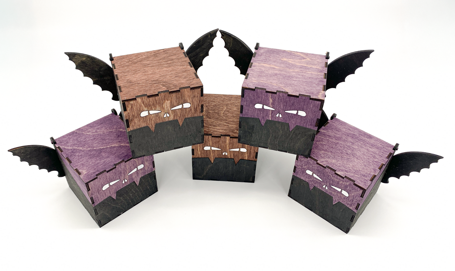 Top view of handcrafted wooden bat boxs with engraved eyes and wings, stained in purple and mahogney