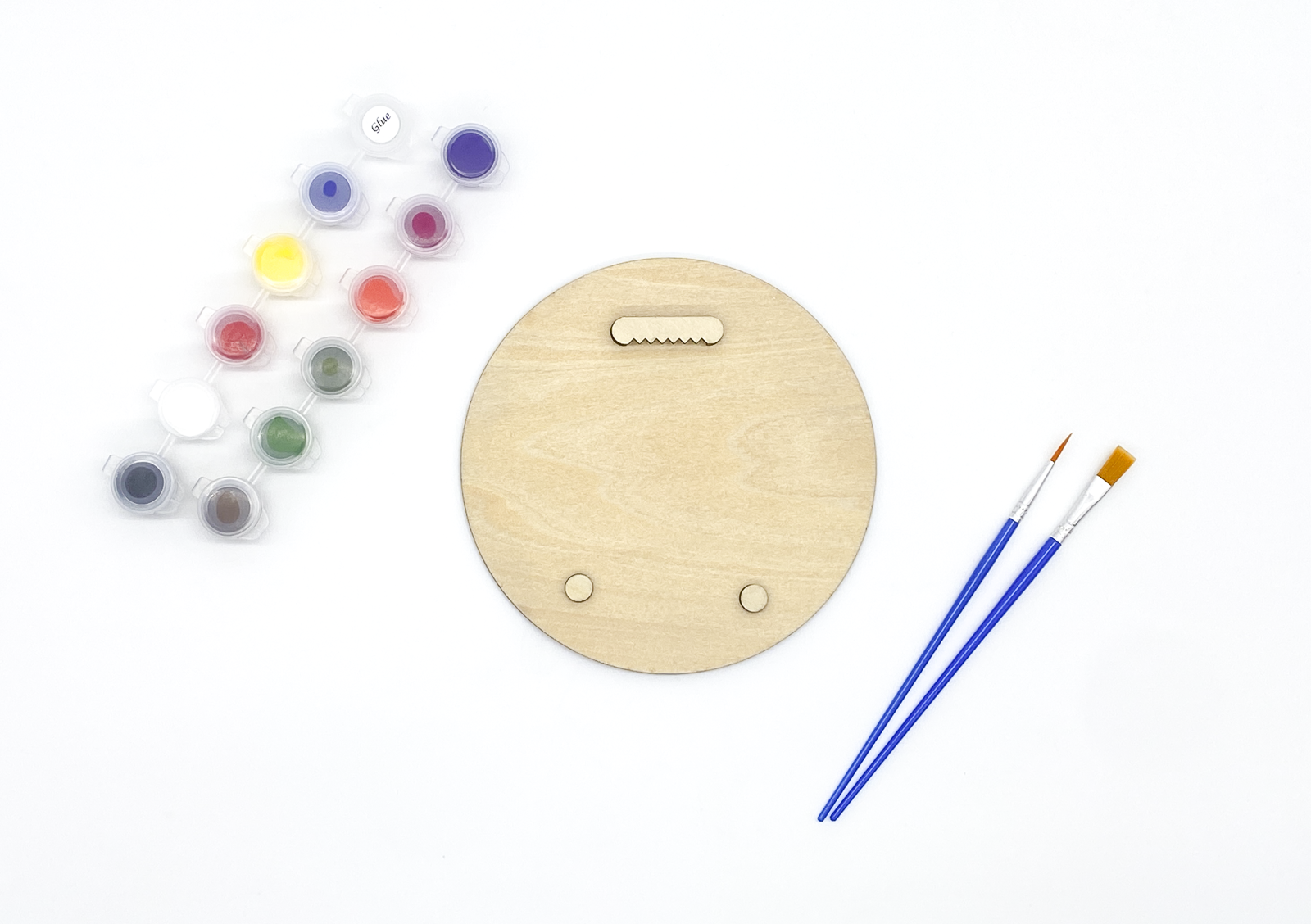 Reverse side of a 6-inch wood art kit showing the installed sawtooth hanger, wall bumpers, paint pots, and detail brushes