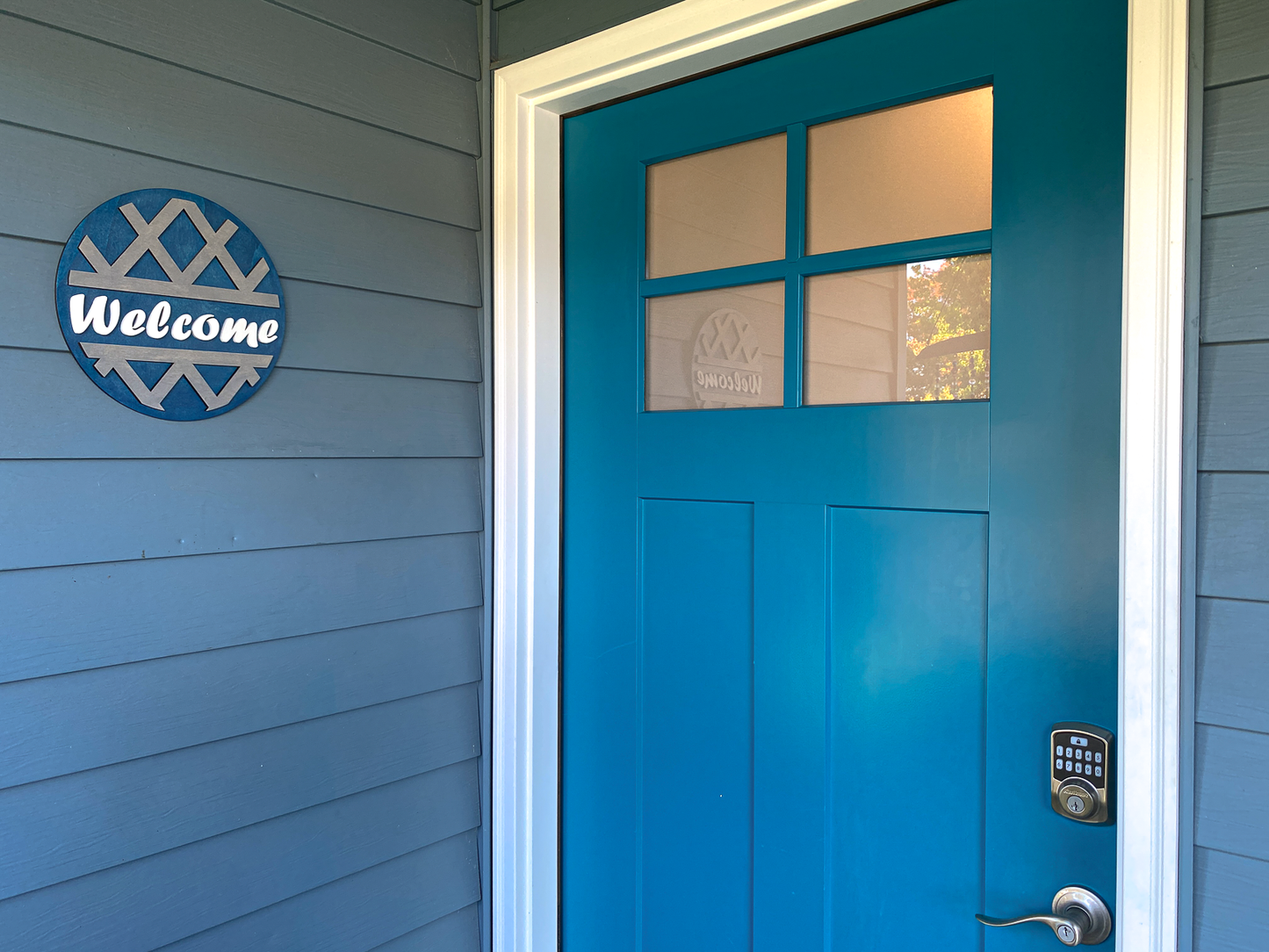 Blue door with a 'Welcome' sign on a gray wall