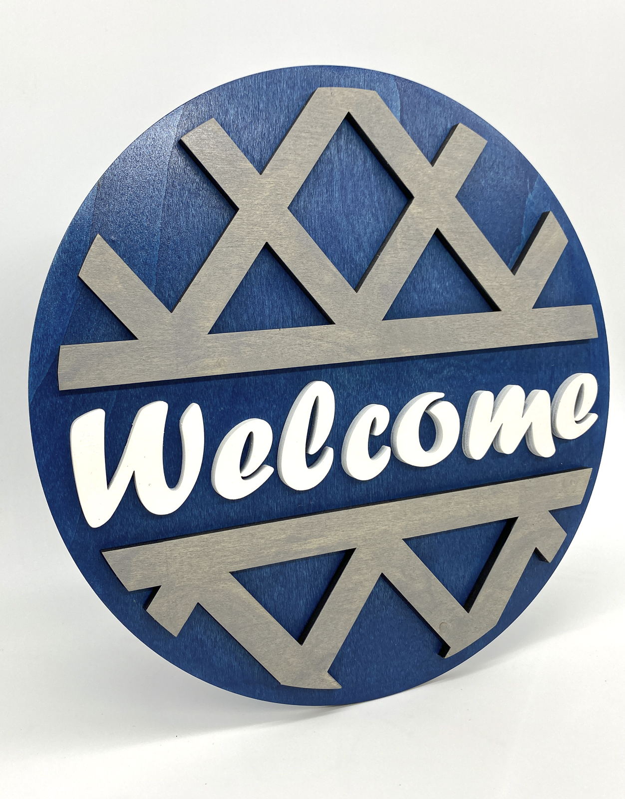 Decorative sign with 'Welcome' text on a blue and silver design