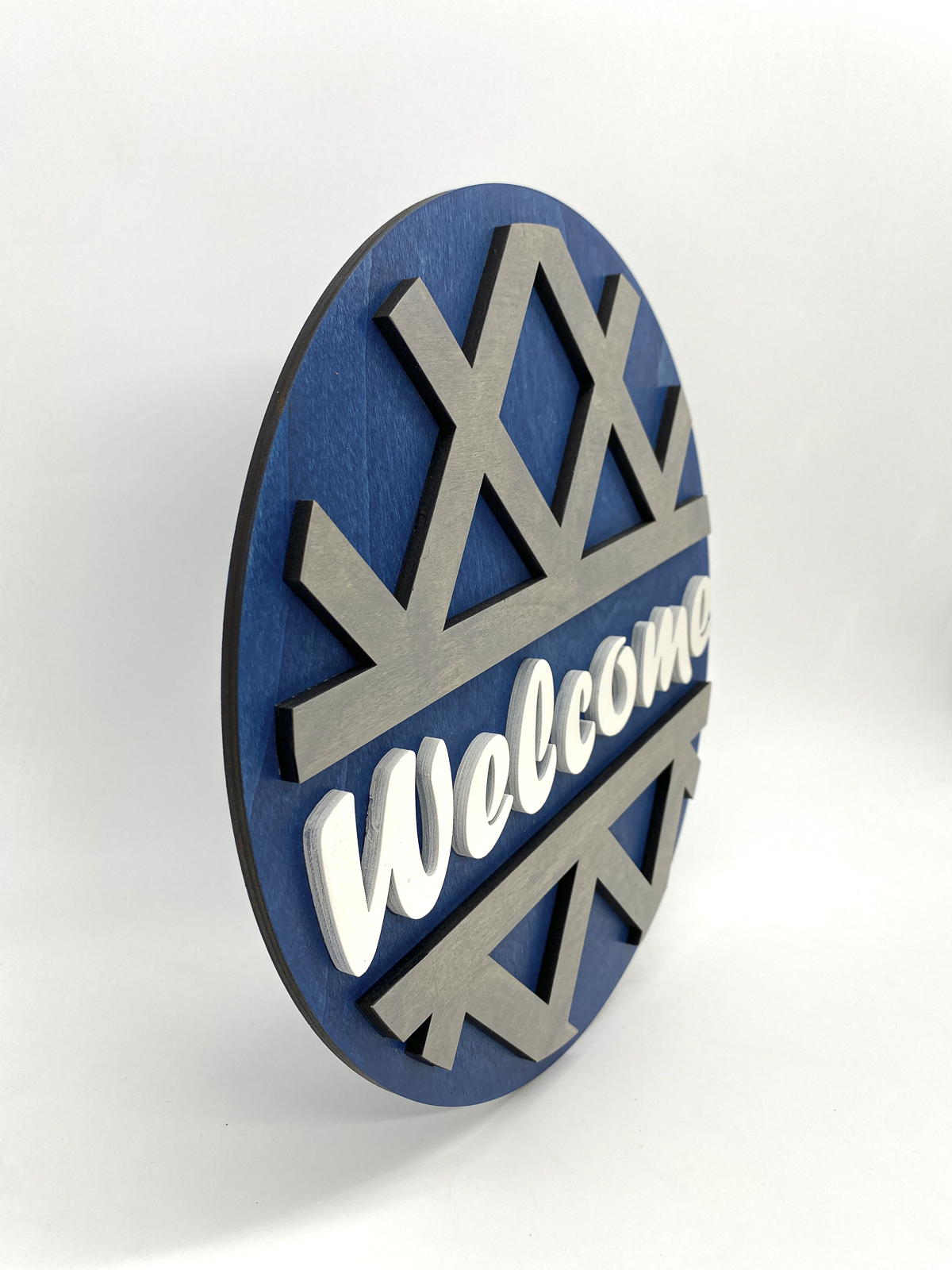 Decorative wall sign with 'Welcome' text on a blue and silver background