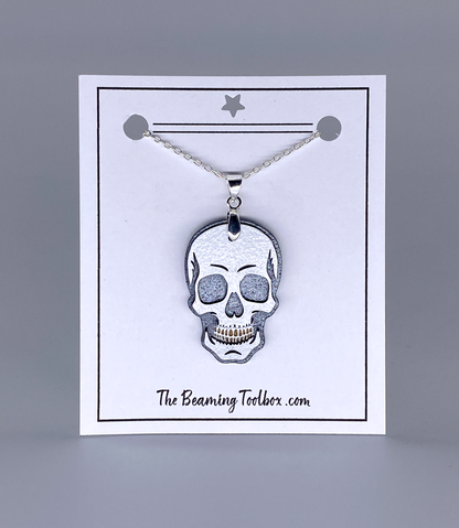 Skull pendant necklace on a display card with 'The Beaming Toolbox' branding.