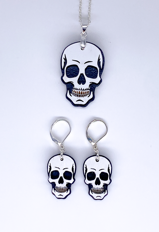 Skull-shaped pendant and earrings on a white background