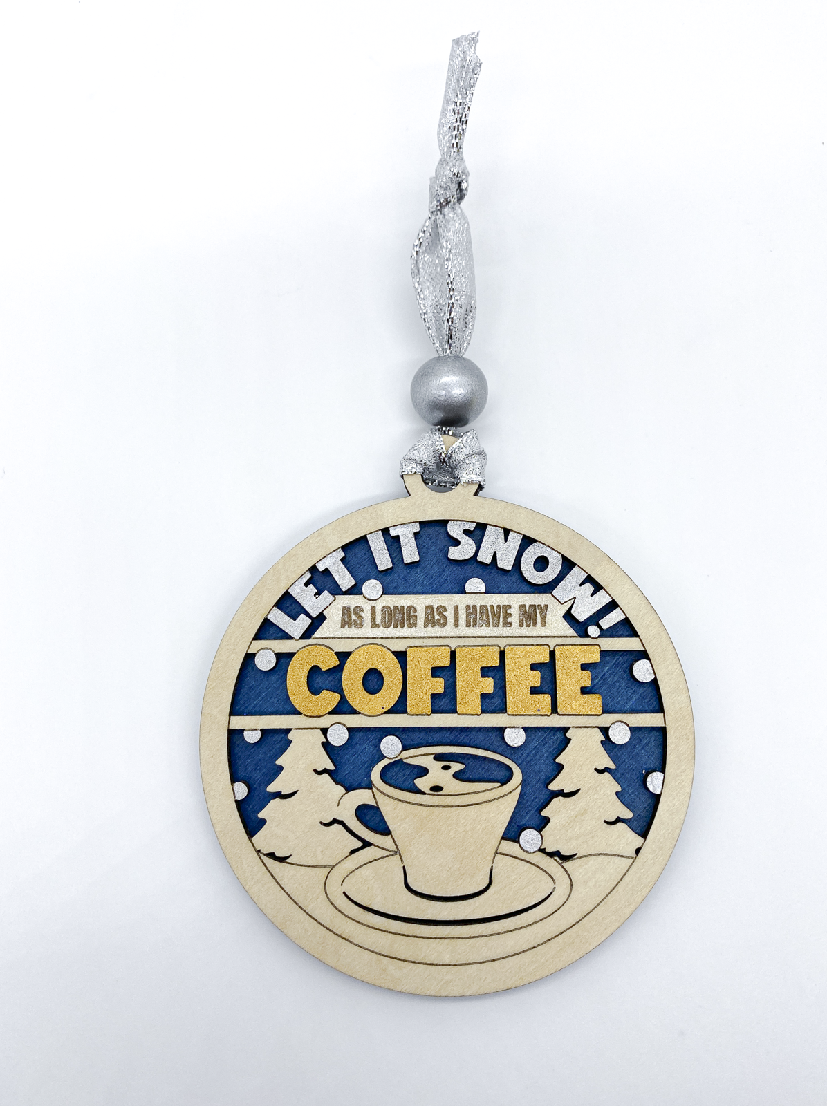 Decorative Christmas ornament with 'Let it snow! As long as I have my coffee' text on a blue background.