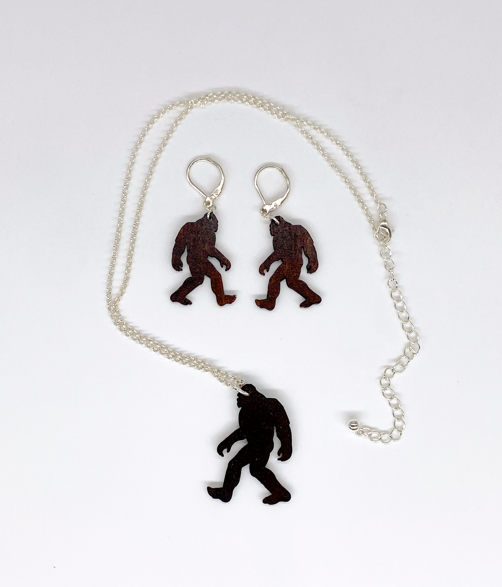 Sasquatch pendant necklace and earrings on a white background.  View of the backside.
