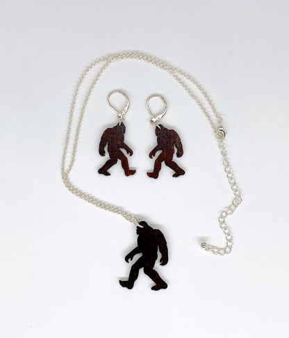 Sasquatch pendant necklace and earrings on a white background.  View of the backside.
