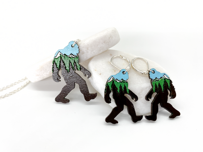 Sasquatch earrings with mountain design on a white background