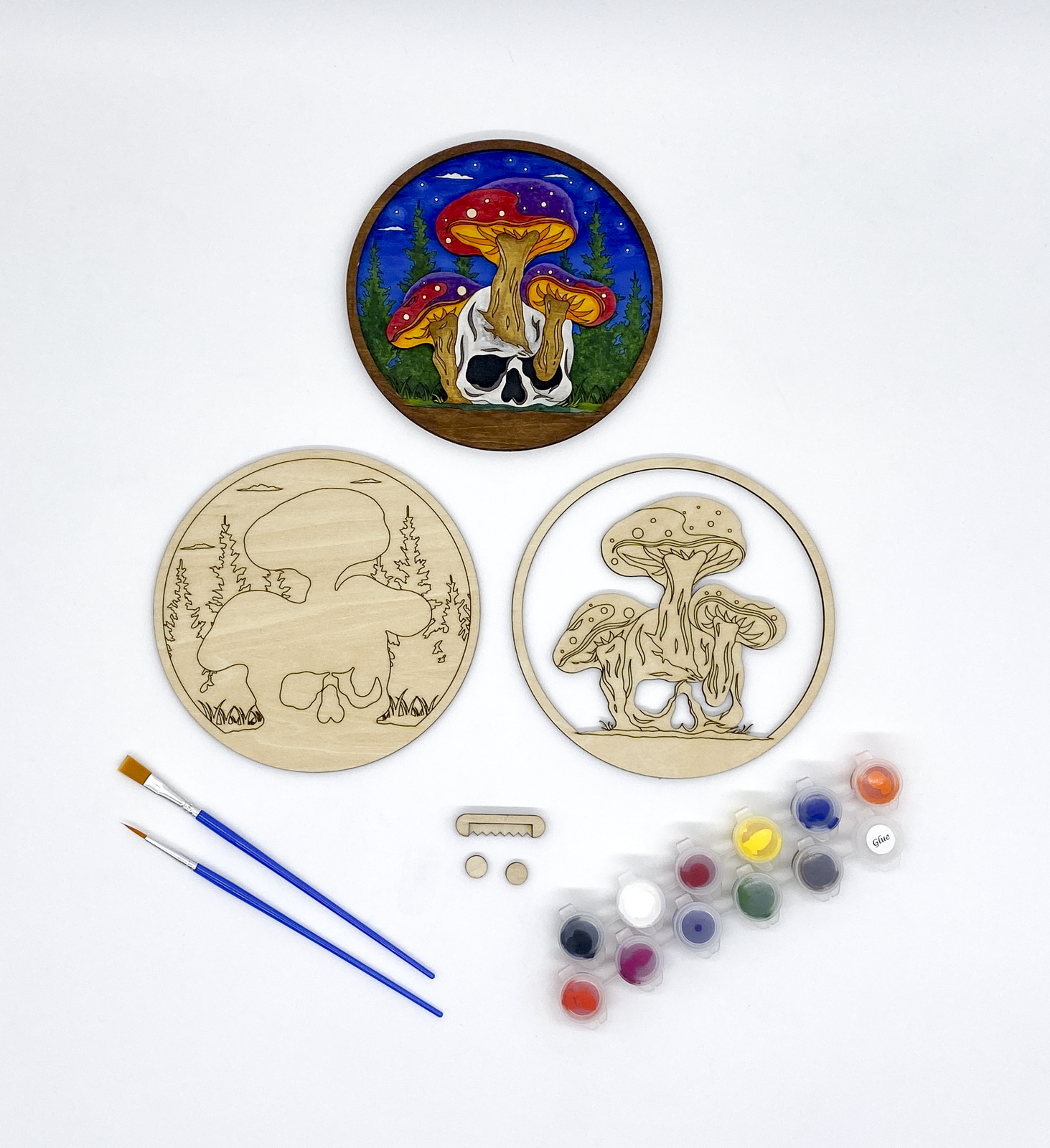 Mushroom and Skull Layered Wood Art kit, showing both layers, sawtooth hanger and bumers, two paint strips and two paint brutshes.