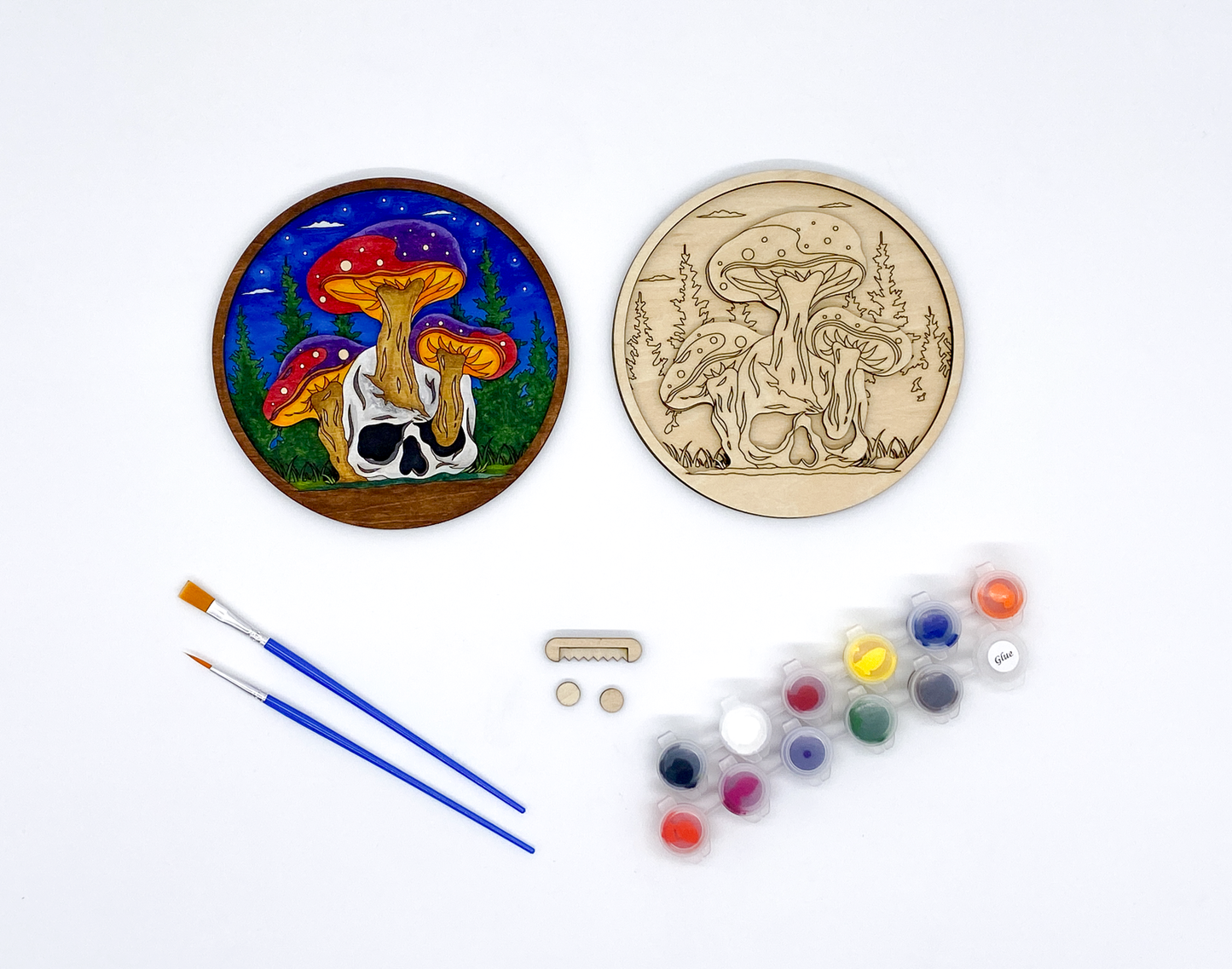 Mushroom and Skull Layered Wood Art kit, showing both layers combined and a completed version of the kit, sawtooth hanger and bumers, two paint strips and two paint brutshes.