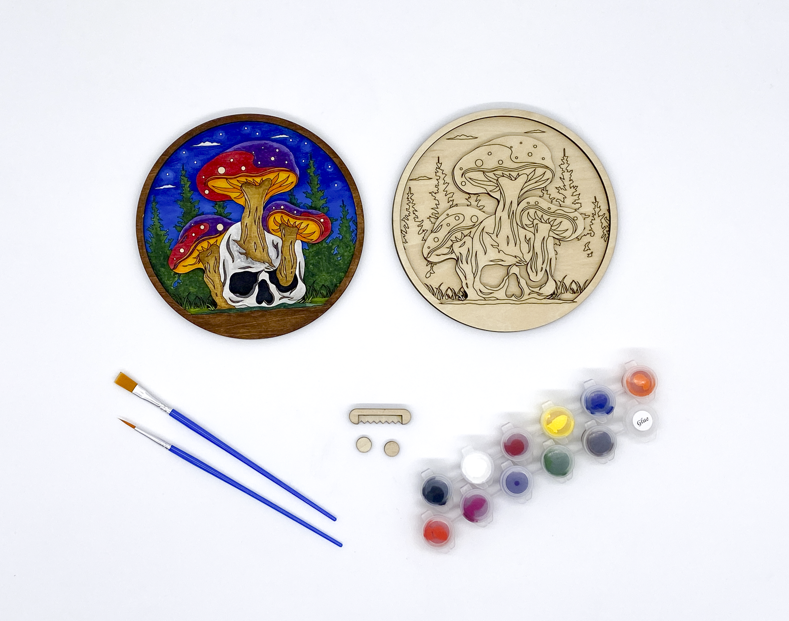 Mushroom and Skull Layered Wood Art kit, showing both layers combined and a completed version of the kit, sawtooth hanger and bumers, two paint strips and two paint brutshes.