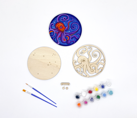 A DIY Paint Kit Featuring A Laser-cut Wooden Octopus, With A Set Of Acrylic Paints And Brushes For Creative Customization.