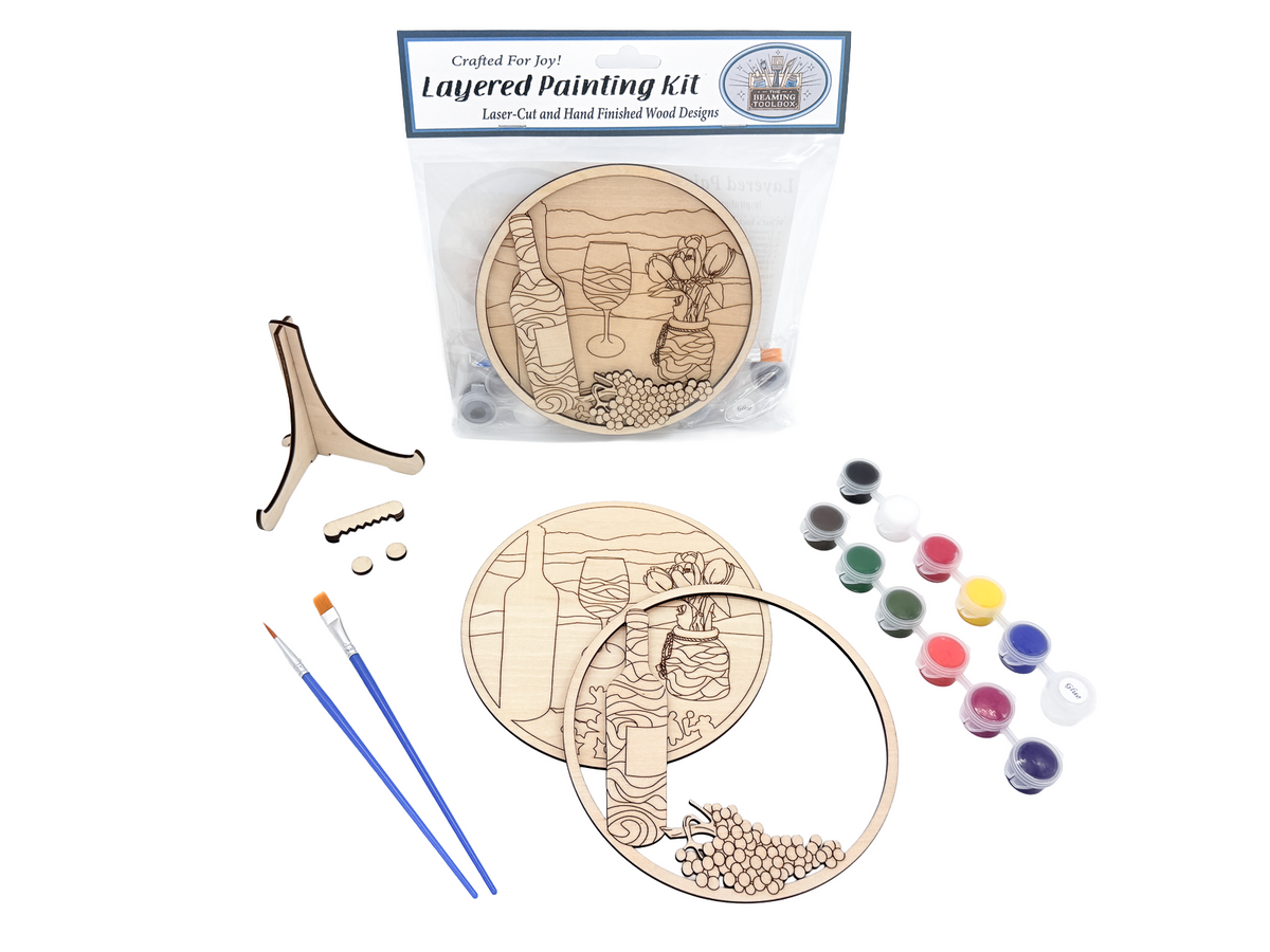 Packaged wine and tulips layered painting kit shown with unpainted laser-cut wood pieces, paint pots, brushes, glue, and display stand hardware.