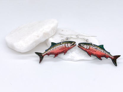 Fish-shaped earrings on a white stone background