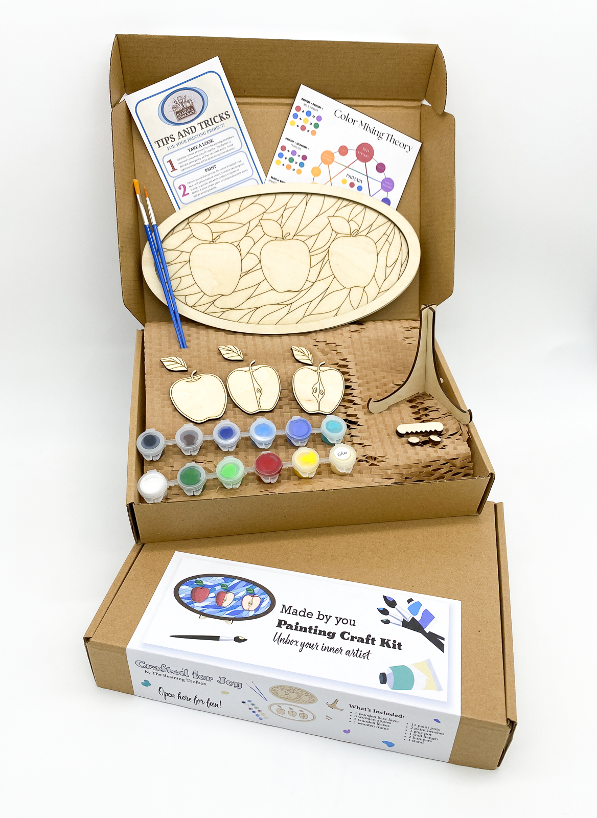 Boxed Apple Joy DIY paint kit packaging showing layered wood apple design and all included kit contents such as paint pots and brushes