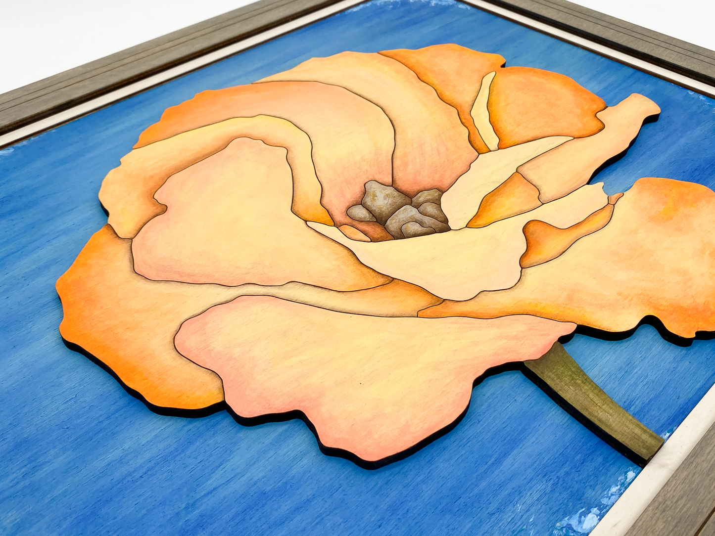 Low-angle close-up of "Apricot Bloom" sculptural wood art, showing the physical 3D layers and the shadow play between the laser-cut birch petals.