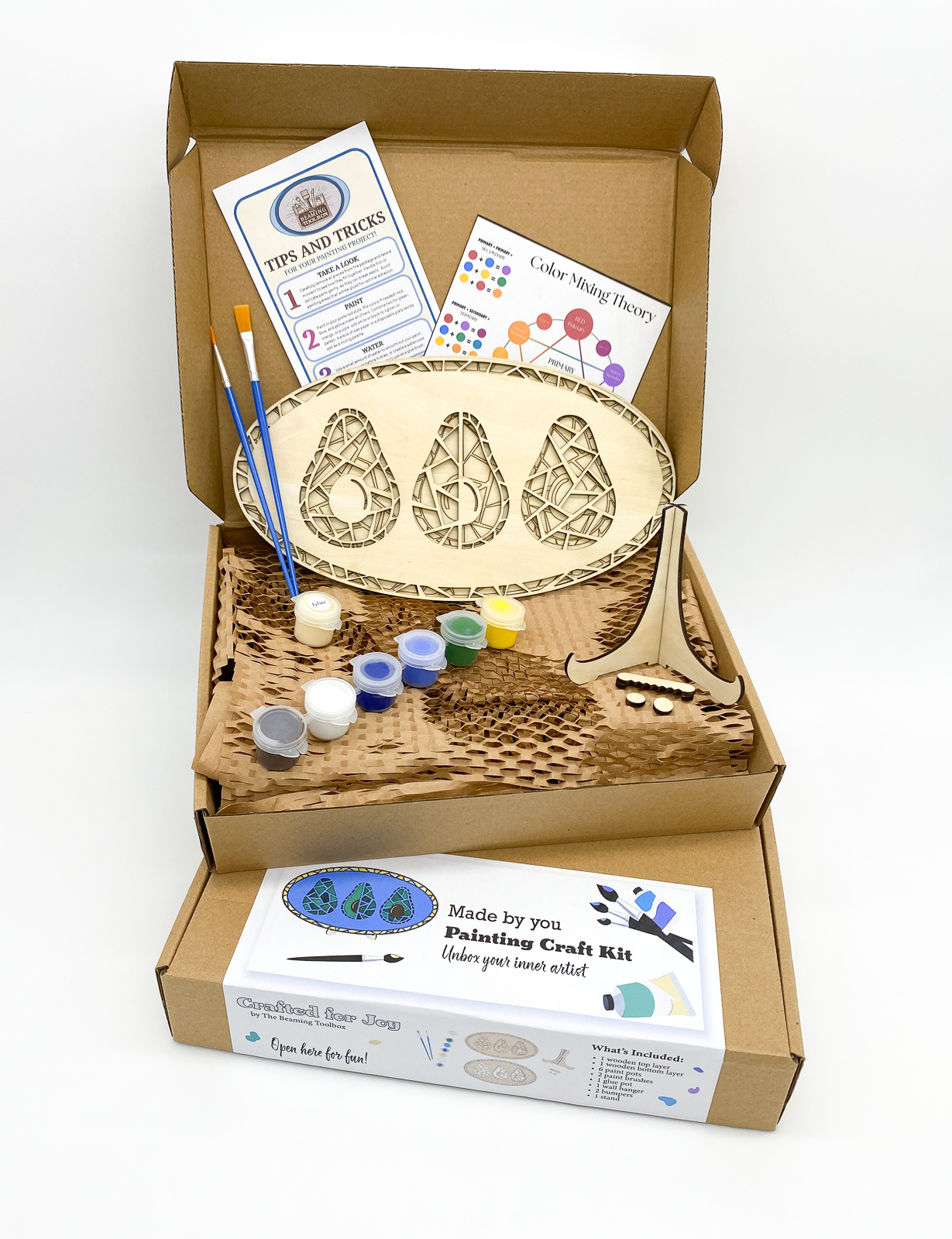 Boxed Avocado Magic DIY paint kit packaging showing layered wood avocado design and all included kit contents such as paint pots and brushes