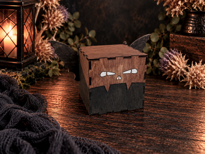 Handcrafted brown wooden bat trinket box with dark wings, engraved white eyes, and hinged lid displayed with a glowing lantern, dried flowers, and rustic Halloween decorations.