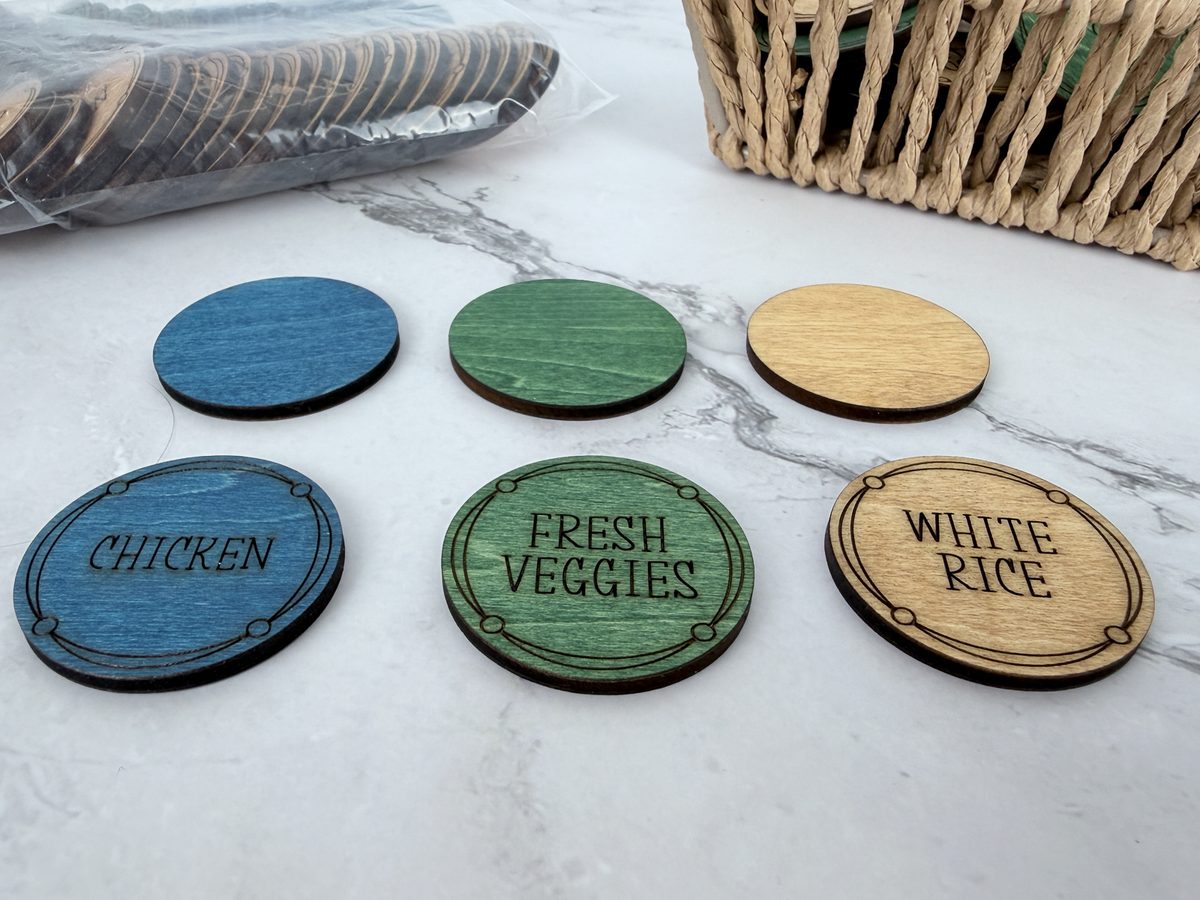 Close-up showing the Build-A-Dinner color system with blue chicken, green fresh veggies, and brown white rice wooden coins.