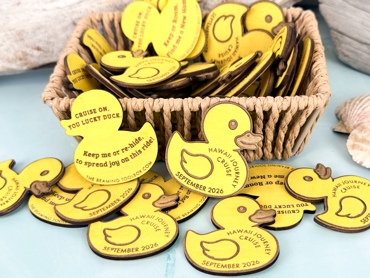 Large group of personalized wooden cruise duck tokens arranged around a basket, showing front and back engraving options.