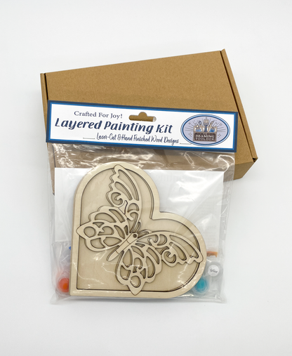 Front of Butterfly Heart DIY paint kit packaging showing layered wood heart with butterfly design and included painting supplies