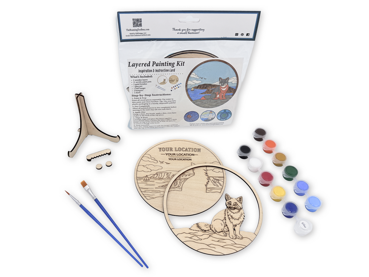 Custom Location Fox adult craft kit with personalized layered wood pieces, paint pots, brushes, glue, display stand, hardware, and packaged guide.