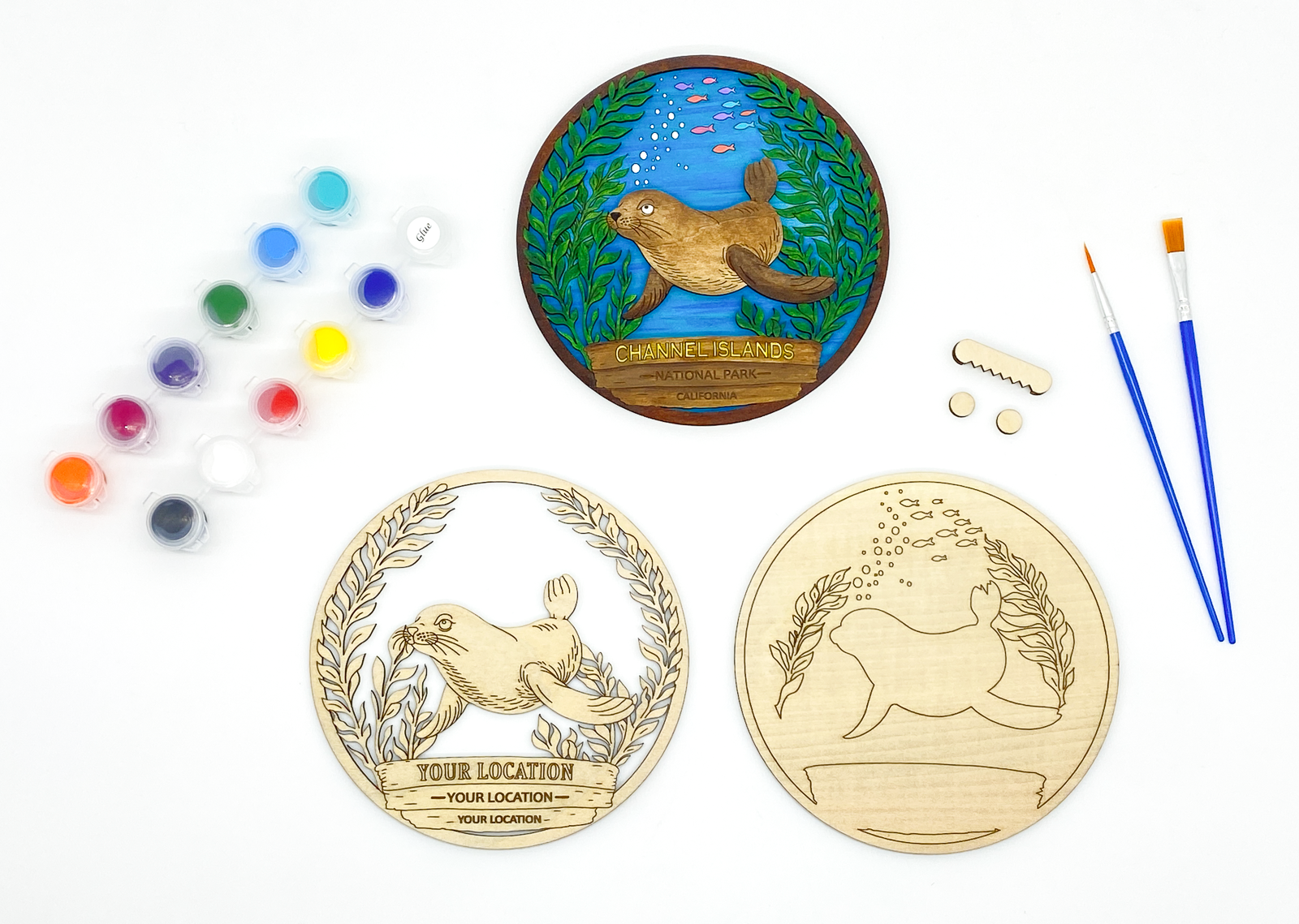 Custom sea lion DIY paint kit with unpainted layers laid flat alongside paints, brushes and hanger hardware