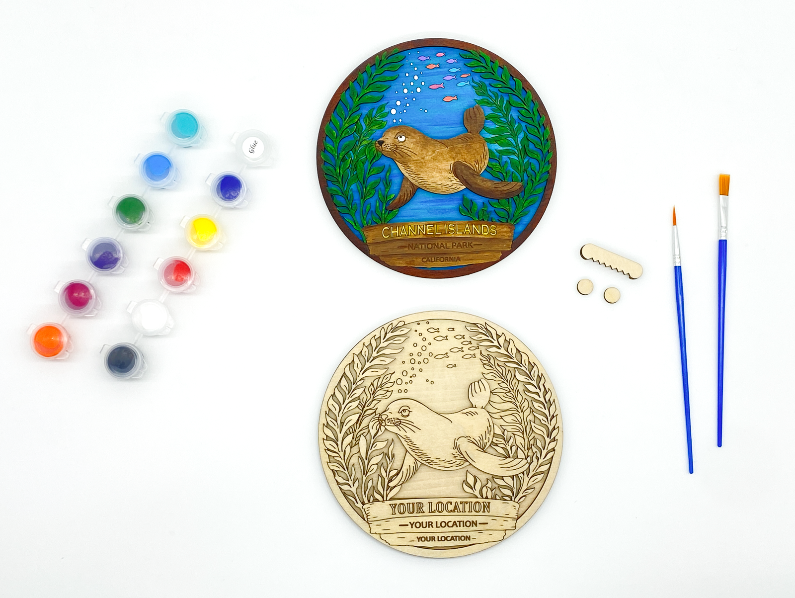 Custom sea lion paint kit with finished sample and stacked wood layers including paint pots and brushes