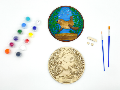 Custom sea lion paint kit with finished sample and stacked wood layers including paint pots and brushes