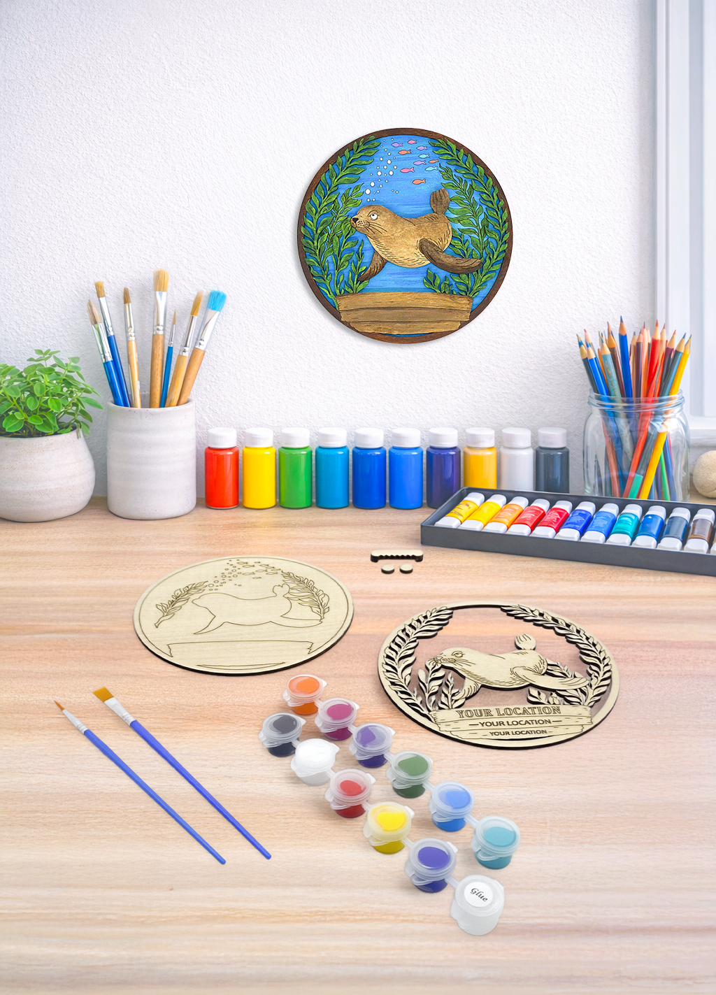Custom sea lion DIY paint kit styled in coastal setting with craft supplies and finished piece displayed