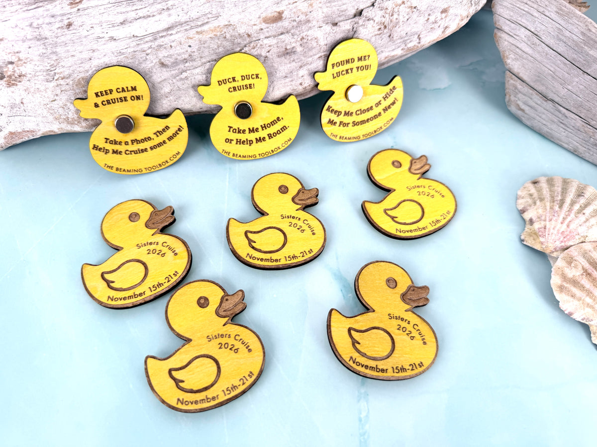 Personalized yellow wooden cruise ducks arranged on a light blue background with driftwood and seashells, showing engraved cruise details and magnetic versions.