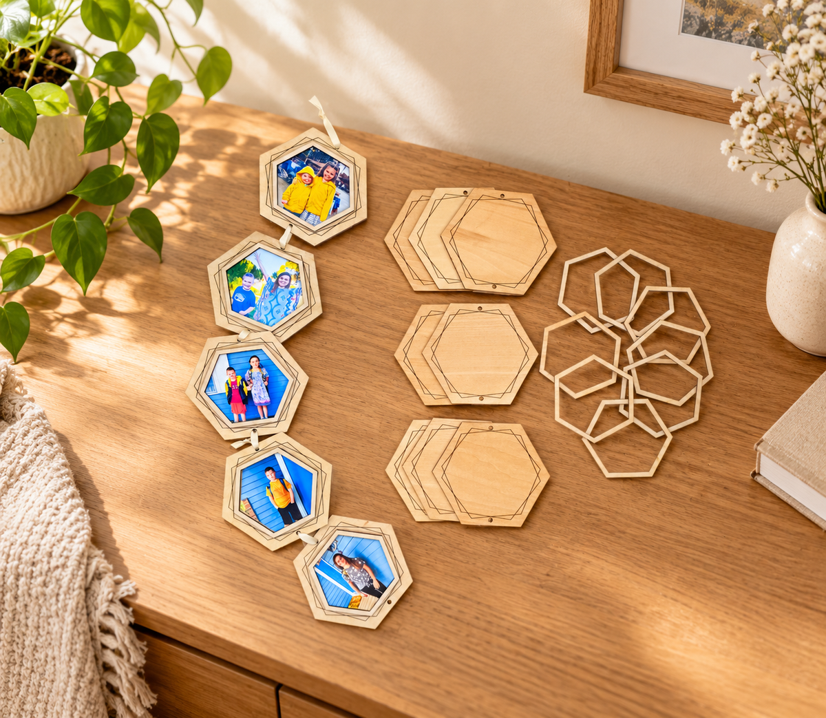 Five light wooden hexagon photo frames connected with cream ribbon, displayed on a wooden table alongside unassembled backings and open frames.