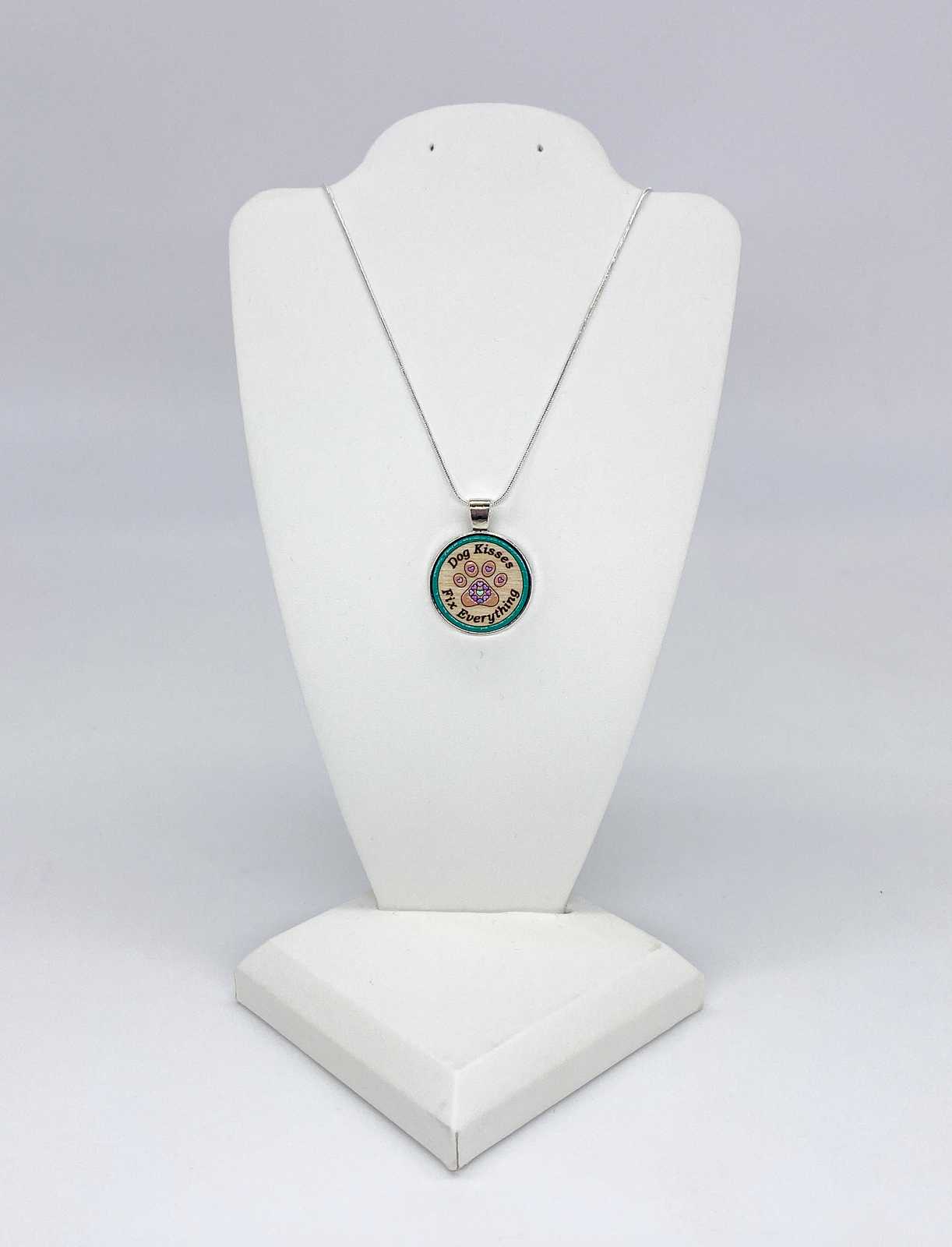 Silver snake chain necklace with wooden paw print pendant displayed on neutral background for dog lovers