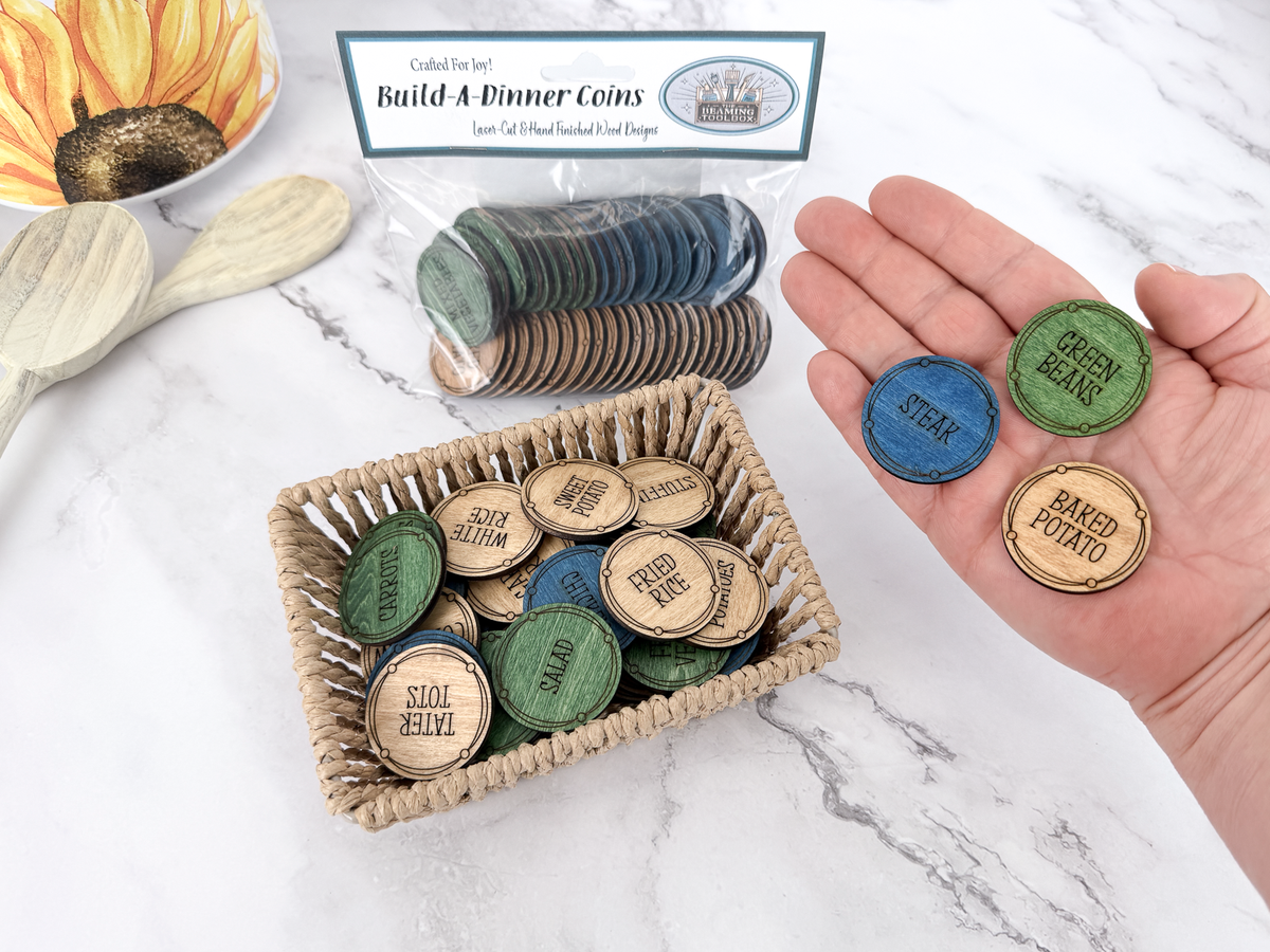 Build-A-Dinner Coins with packaged set, basket of meal choices, and hand holding steak, green beans, and baked potato coins.