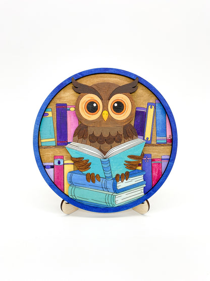 Round diy paint kit completed with an owl reading a book design on a white background